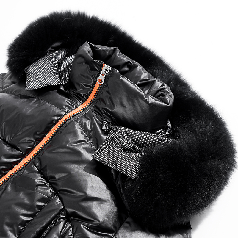 Το μακρύ ζεστό παλτό της γυναίκας με αποσπώμενη κουκούλα